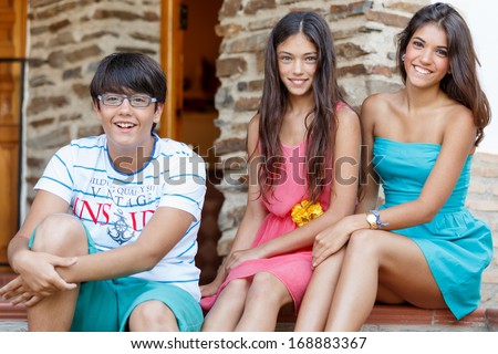 two girls and a boy sitting on the stairs of the holiday house