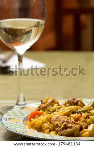 bowl of rice with rabbit and glass of white wine