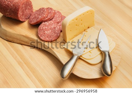 wurst and cheese on a wooden cutting board. Snack with beer or wine