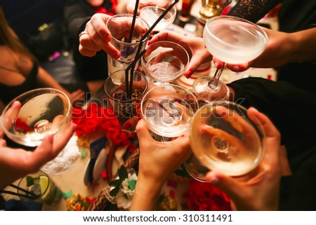Clinking glasses with alcohol and toasting, party