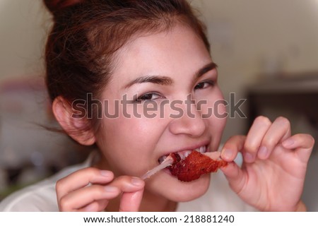 Woman eating a delicious chicken. The spicy taste And it can reduce weight by only eating meat. It made her very happy.