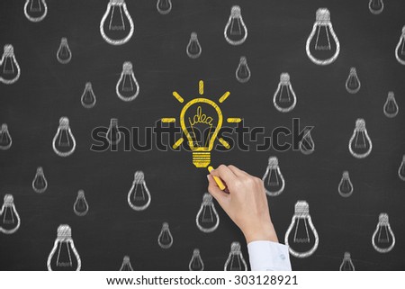 Idea Yellow Light Bulb Concept Rain Drawing on Blackboard