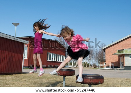 Two beautiful jumping girls in the school garden