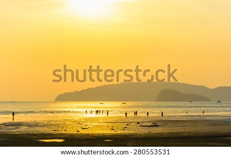 Tourists walk and play at Nang bay Krabi Thailand in sunset light.