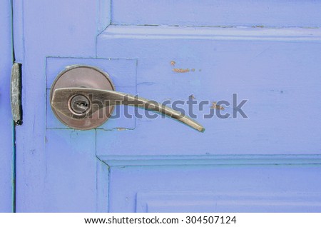 Metal doorknob with purple blue pastel wood door