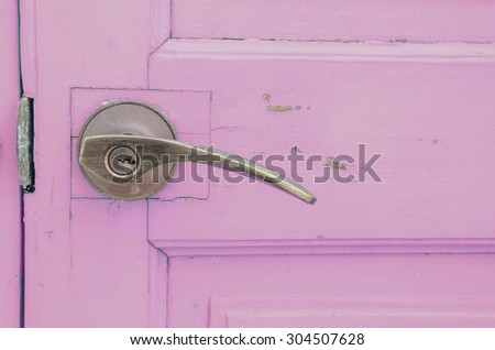 Metal doorknob with purple pastel wood door