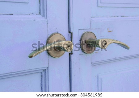 Metal doorknob with pastel blue purple wood door