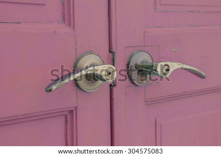 Metal doorknob with pastel purple wood door