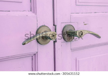 Metal doorknob with pastel purple wood door