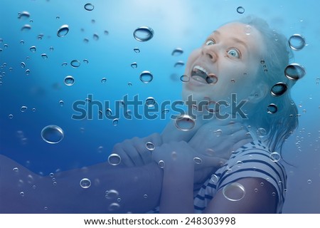 Young woman being strangled under the water with bubbles around
