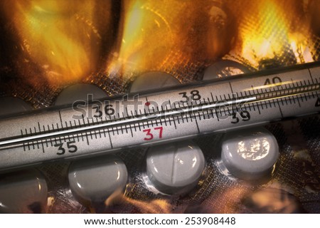 Mercury thermometer showing high temperature and tablets in fire
