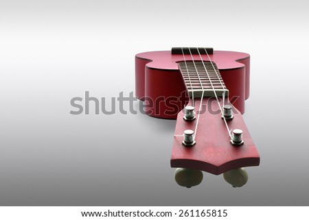 Small guitar Ukulele in a grey gradient background