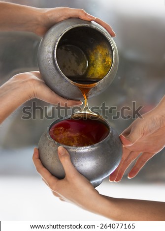 Honey, two old pots and four young woman\'s hands near a window