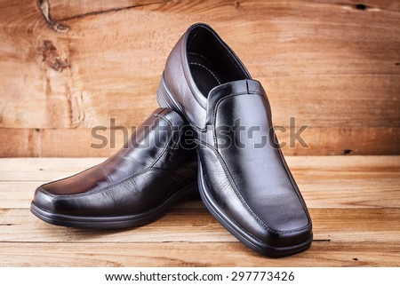 Classic black men's shoes on wood background
