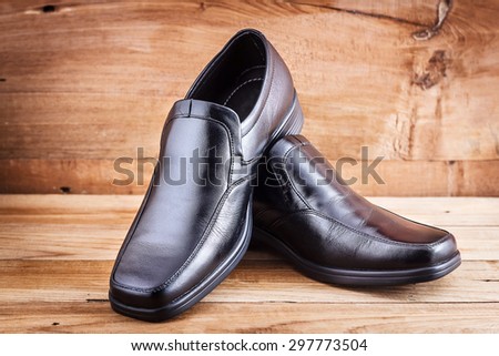 Classic black men\'s shoes on wood background