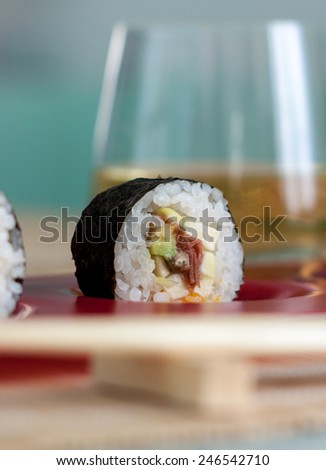 Vegan sushi roll on a plate and white wine