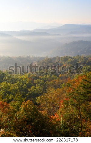 The sun rises over the mountains of Great Smoky Mountains National Park at the peak of autumn\'s colors. This is looking east into the Smoky mountains from the Foothills Parkway West.