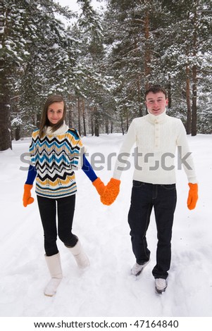 Young people walk in wood in winter
