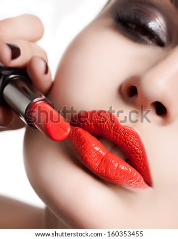 Sexy lips. Beauty red lips applyinf lipstick. Beautiful make-up. closeup. macro. Fashion. Sensual open mouth. lipstick , face, hand, studio shot, beautiful woman