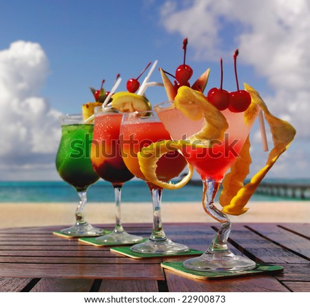 four cocktails on the beach on the table, outdoors, fresh fruits, exotic, tropical, summer, refreshment