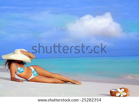 attractive young woman in bikini  in hat lying on the beach on the sand. Ocean, sea, seascape, vacation, body, sexy, sunbathing, tropical