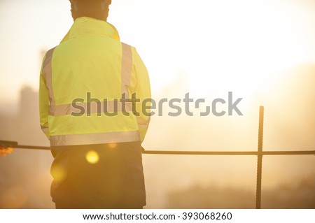 Worker at the construction site and sunrise background