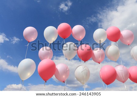 Balloons on threads against the sky and clouds