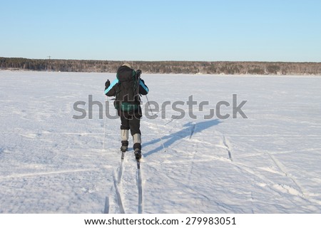 The man the traveler with a backpack skiing on the river
