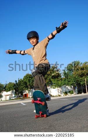 Boy doing stunts on a skateboard in afternoon sun with blue sky in the background