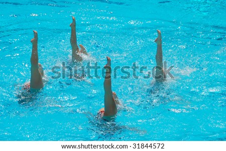 A four women synchronized swimming team performing.