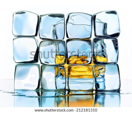 a glass of whiskey behind ice cubes on a white background