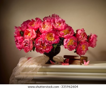 bouquet from peonies with old box with beads on table on beige background