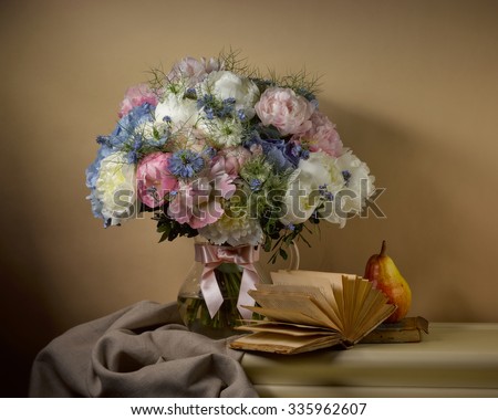 bouquet from peonies with opened book and pear on table on beige background