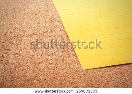 Line yellow sticky note on cork board with filled text blank space