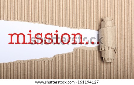 Mission text on white paper with copy space and torn cardboard