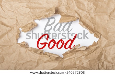 Good and bad words on white paper with copy space and torn cardboard