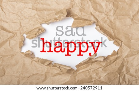Happy and sad words on white paper with copy space and torn cardboard