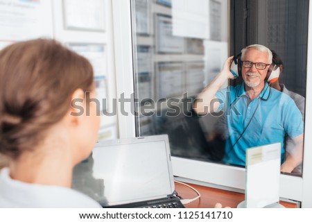 Senior man getting a hearing test at a doctors office, audiometer hearing test