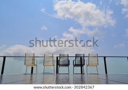 Magnificent outdoor terrace with chairs on sunny terrace with bay view and decoration in contemporary home.