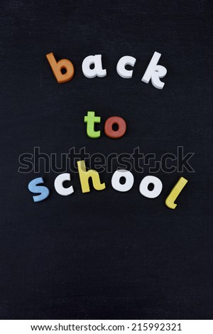Colorful letters arranged to say \'Back to School\' on a Chalkboard background.