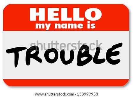 A namtag sticker with the words Hello My Name is Trouble representing a problem, issue, annoyance, mischief, danger, pain or stress