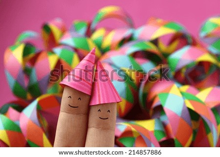Happy party couple wearing pink party hats - drawn on fingers