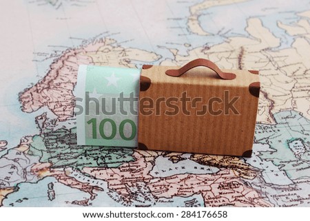 Europe city trip travel budget concept with 100 euro note and suitcase on map