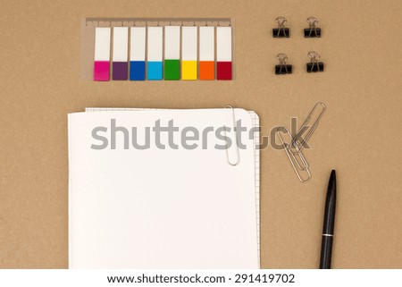 Top view of blank notepad with organizing supplies on desk