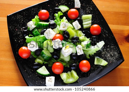 Fresh Greek salad dressed with olive oil and rosemary, closeup