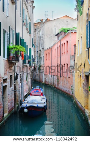 Serene landscape of a narrow canal with a boat in Venice