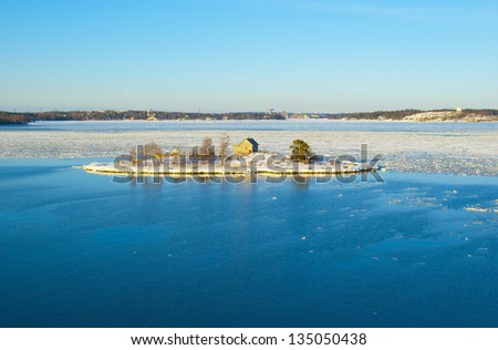 Snowy island in the middle of the ice drift in the Baltic sea in Finland