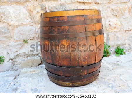 Wine wooden barrel near the old wall