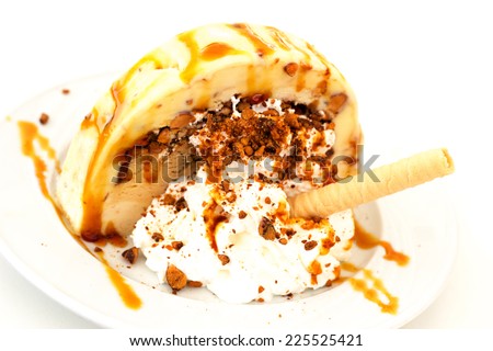 Delicious coffee and caramel ice cream with nuts and poured caramel syrup.