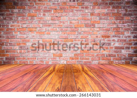 Grungy textured red brick and stone wall with warm brown wooden floor inside old neglected and deserted interior, masonry and carpentry brickwork concept
